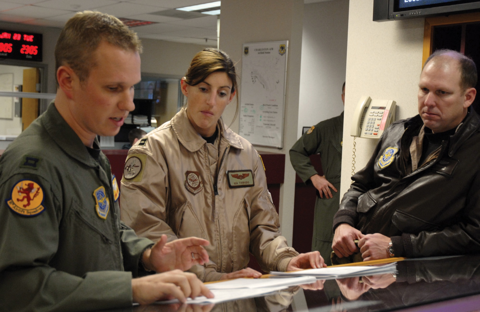Capt. Kenny Weiner, 16th Airlift Squadron command post duty officer, conducts a mission briefing with Capt. Gia Thibodo and Lt. Col. Jon Fullerton, 8th Airlift Squadron pilots from McChord AFB, Wash., as part of Charleston’s AFSO 21 sequence of events initiative. (U.S. Air Force photo/Senior Airman Sam Hymas)