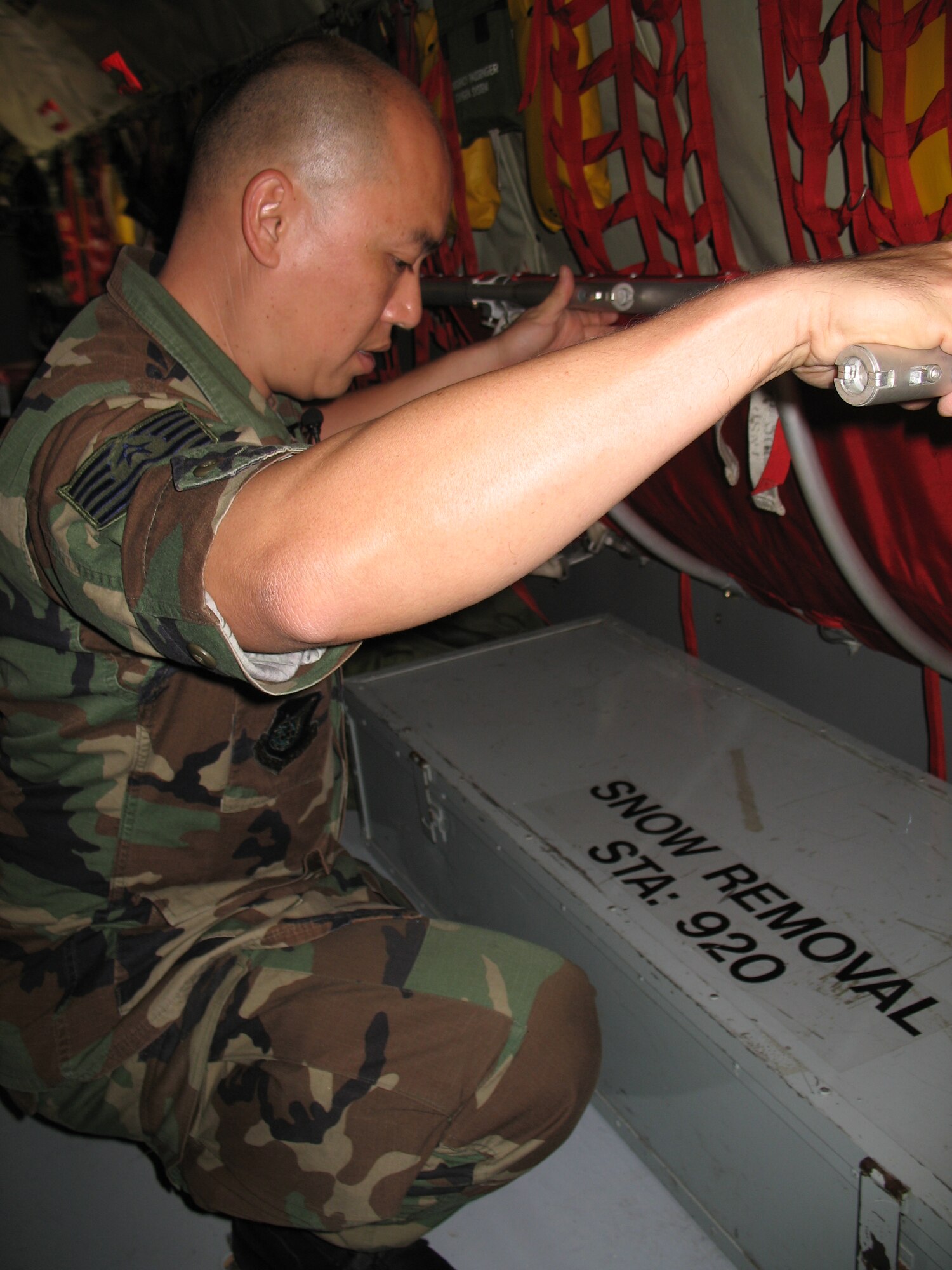 Tech. Sgt. Steward Leong shows equipment that can be offlaoded as excess before a mission as part of a KC-135 Stratotanker fuel saving initiative at Hickam Air Force Base, Hawaii, Jan. 25, 2007. Sergeant Leong is a KC-135 crew chief with the Hawaii Air National Guard, 154th Aircraft Maintenance Squadron. (U.S. Navy photo/Petty Officer Jason Segedy)