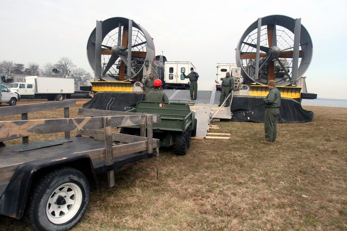 Sailors from Naval Station Norfolk, Va., help a Marine with Company B, Chemical Biological Incident Response Force, II Marine Expeditionary Force, load a Landing Craft, Air Cushioned, here Jan 27. LCACs are designed to transport tactical vehicles the military uses in combat. CBIRF uses LCACs in response to real-world chemical, biological, radiological, nuclear or high yield explosion incidents.
