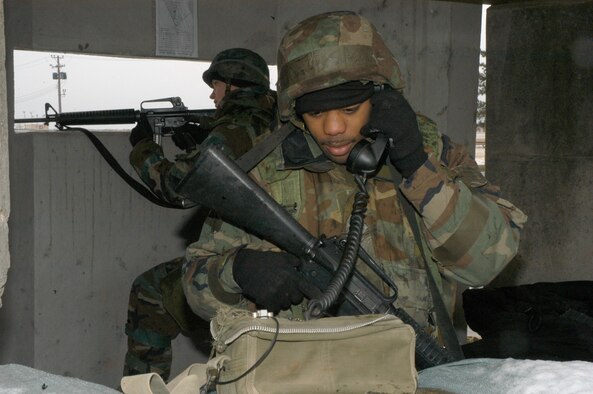 KUNSAN AIR BASE, Republic of Korea Jan. 26, 2007 -- READY augmentee Airman 1st Class Taquaan Dublin calls in a status report while wingman Airman 1st Class Kyle Stanek keeps a watchful eye out for the enemy Jan. 26. The Airmen, both assigned to the 8th Maintenance Operations Squadron, are augmenteed out to the 8th Security Forces Squadron as part of the base defense plan in the event the installation increases its defensive posture. This exercise, known as a peninsula-wide combat employment readiness exercise, or PENCERE, is the first of its kind for 2007.                                