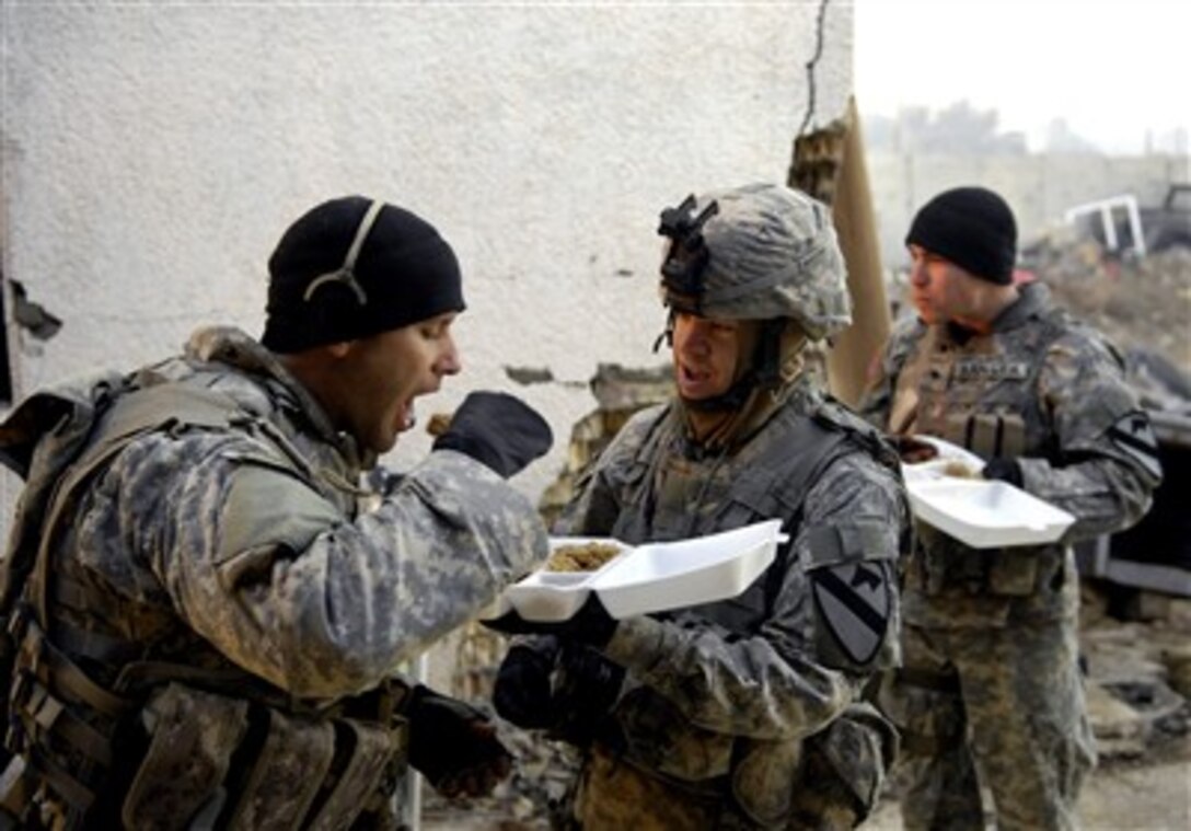 U.S. Army soldiers from 1st Cavalry Division share chow after conducting a mission in Buhriz, Iraq, Jan. 28, 2007.