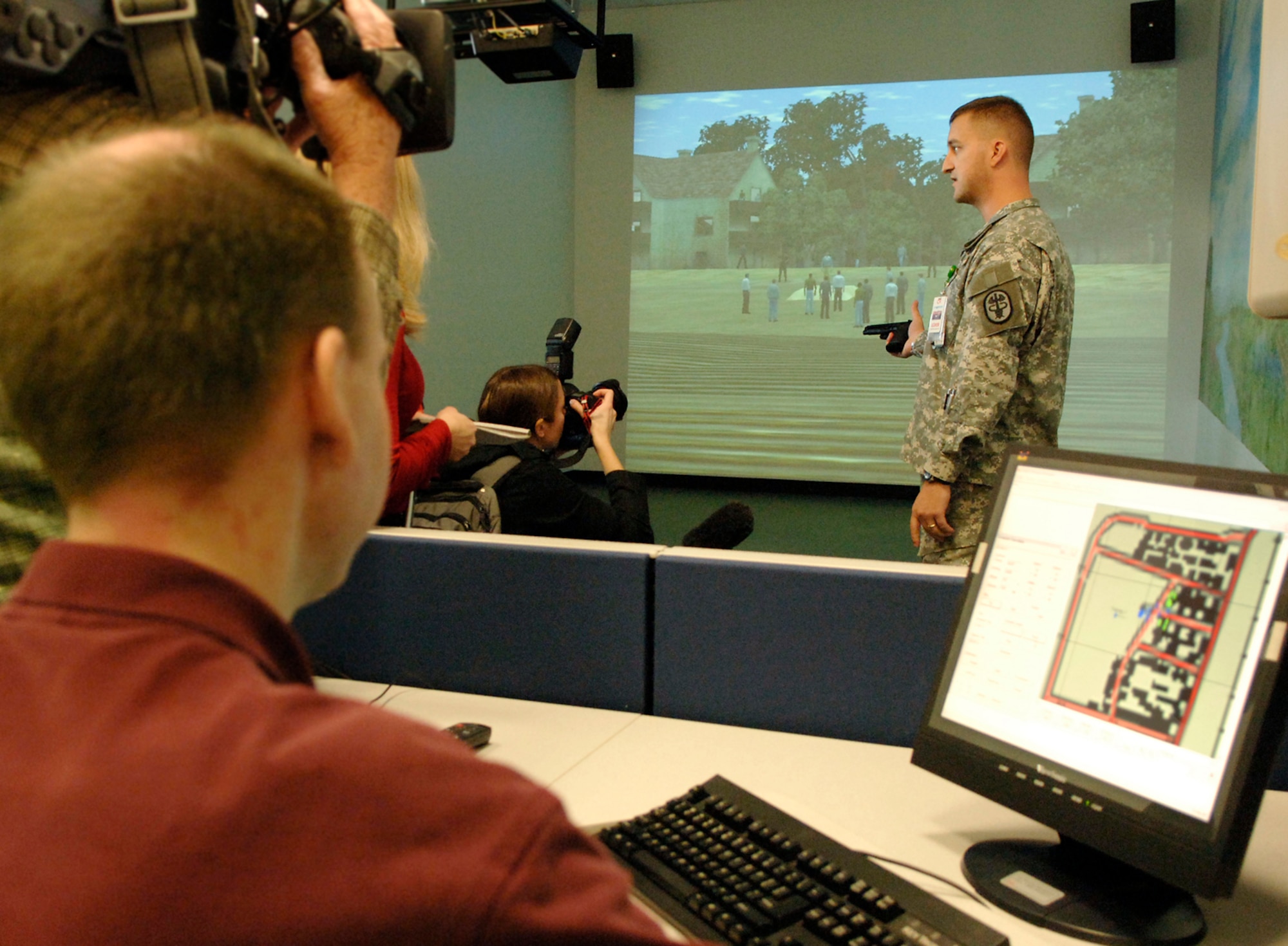 Capt. Scott Kulla demonstrates firing a replica of the 9 mm pistol using the firearms training simulator, a virtual firing range at the Center for the Intrepid in San Antonio Jan. 29. (U.S. Air Force photo/Daren Reehl)