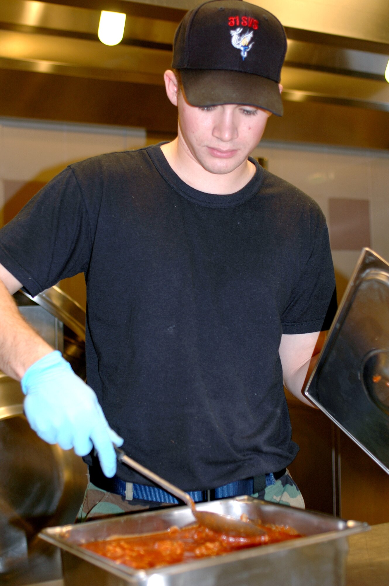 Airman Luis Lugo-Velez stirs sauce he prepared for meatball sandwiches Jan. 23 at the La Dolce Vita Dining Facility on Aviano Air Base, Italy. The La Dolce Vita Dining Facility serves 600 meals a day on average. Each shift prepares for the next shift. For example, the midnight shift prepares the morning meal, so the morning shift can come in and serve the food, clean up, and cook lunch. Airman Lugo-Velez is a 31st Services Squadron food service technician. (U.S. Air Force photo/Senior Airman Colleen Wieman)
