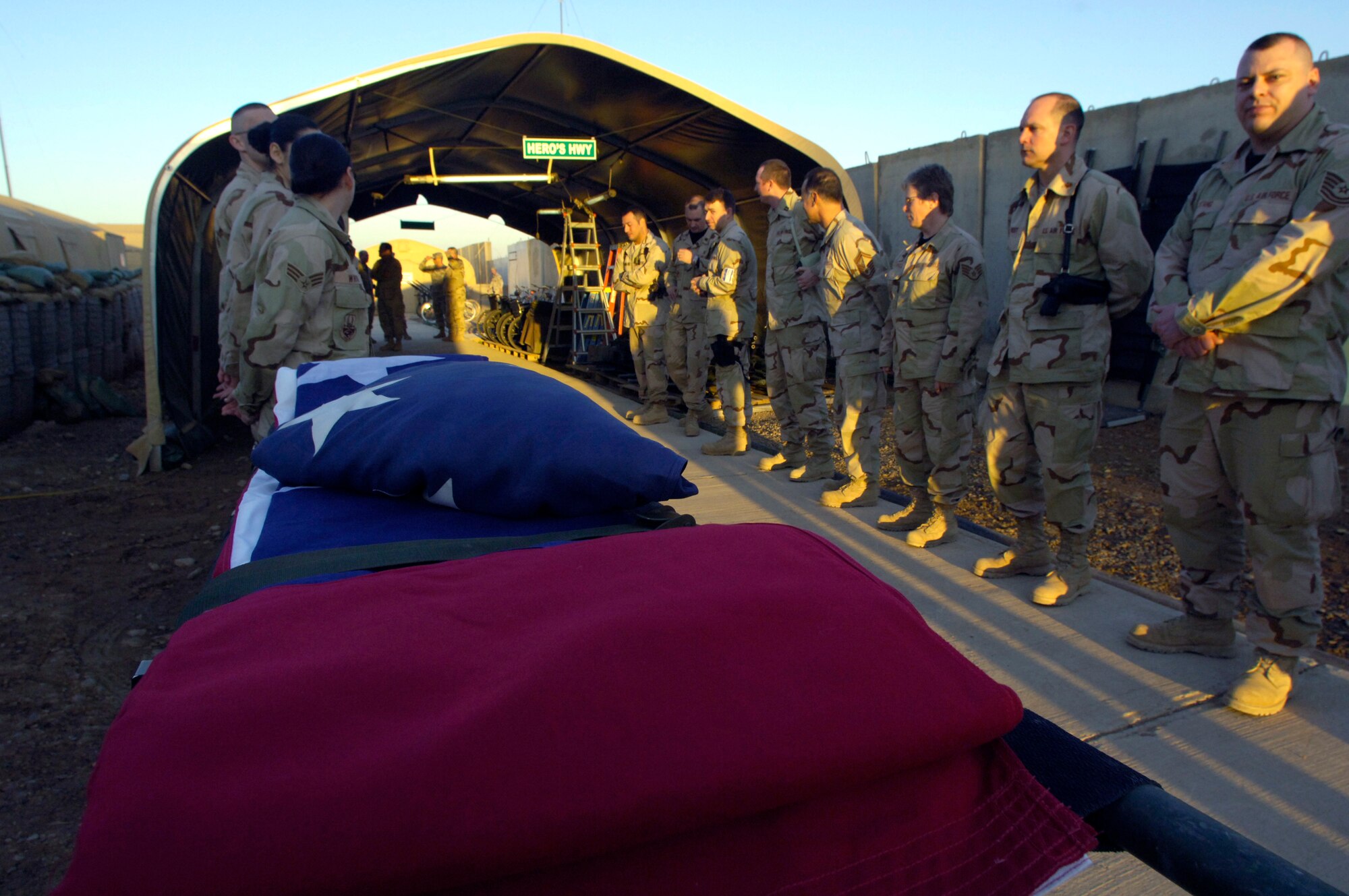 Airmen deployed to the 332nd Air Expeditionary Wing unfold an American flag at the Hero's Highway Ceremony Jan. 22 at Balad Air Base, Iraq. The flag is posted on the inner roof a tent so injured troops can look up and know they are in an American area when brought in on litters seeking medical treatment. The medical group raised injured troops' survival rate to 98 percent. (U. S. Air Force photo/Airman 1st Class Nathan Doza) 
