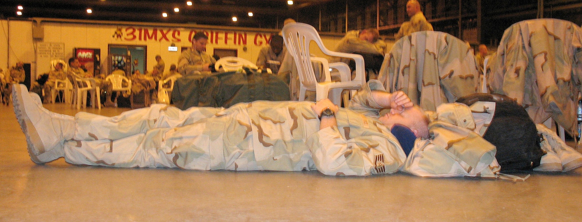 Staff Sgt. James Ward rests at Hangar One while waiting for transportation to a forward-operating location in support of Operation Iraqi Freedom Jan. 18 at Aviano Air Base, Italy. Sergeant Ward is assigned to the 15th Civil Engineer Squadron from Hickam Air Force Base, Hawaii. (U.S. Air Force photo/Tech. Sgt. Amy Velasquez) 


