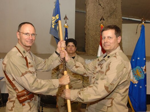Kirkuk Regional Air Base, Iraq -- Air Force reservists Lt. Col. Tom Kuepper (right) deployed from the 445th Civil Engineer Squadron at Wright-Patterson AFB, Ohio receives the 506th Expeditionary Civil Engineer Squadron guidon from Col. Gregory Schwab (left) 506th Air Expeditionary group commander at Kirkuk RAB, Iraq on January 14. Senior Master Sgt. Lisa Rodriguez (center) is from the 445th Airlift Wing deployed as 506th Civil Engineer First Sergeant. More than 60 civil engineers from the 445th CES deployed to Kirkuk, Iraq to support the Global War on Terrorism (U.S. Air Force/SrA Bradley Lail).

