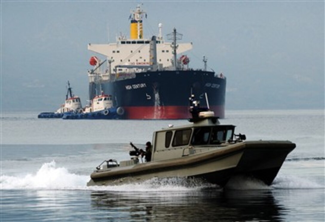 A harbor security boat assigned to Naval Support Activity Souda Bay patrols the area as tugs assist the Military Sealift Command contract tanker High Century during her arrival for a port visit at Souda Bay, Crete, Greece, Jan. 23, 2007.