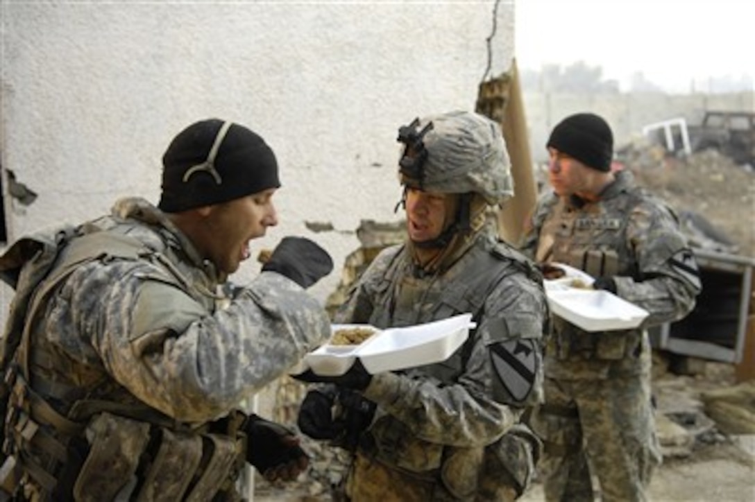 Soldiers from the U.S. Army's 1st Cavalry Division share chow after conducting a mission in Buhriz, Iraq, on Jan. 28, 2007.  