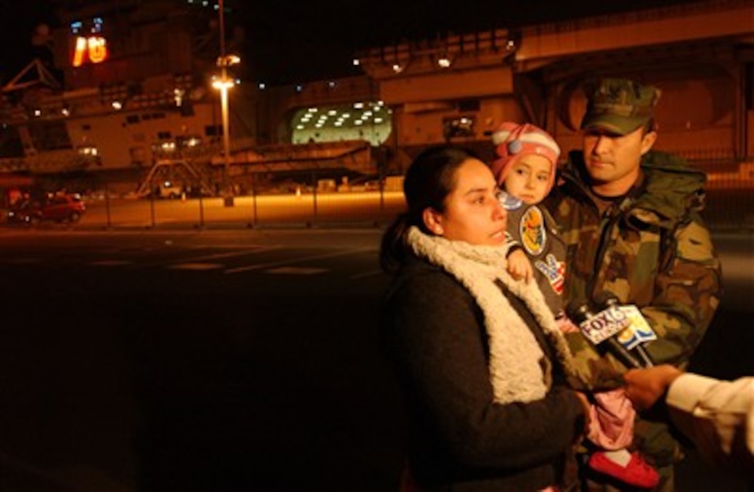 Local news media interview a sailor and his family in the early morning hours Jan. 27 in San Diego, Calif., aboard Naval Station North Island, as the Nimitz-class aircraft carrier USS Ronald Reagan prepares for deployment.