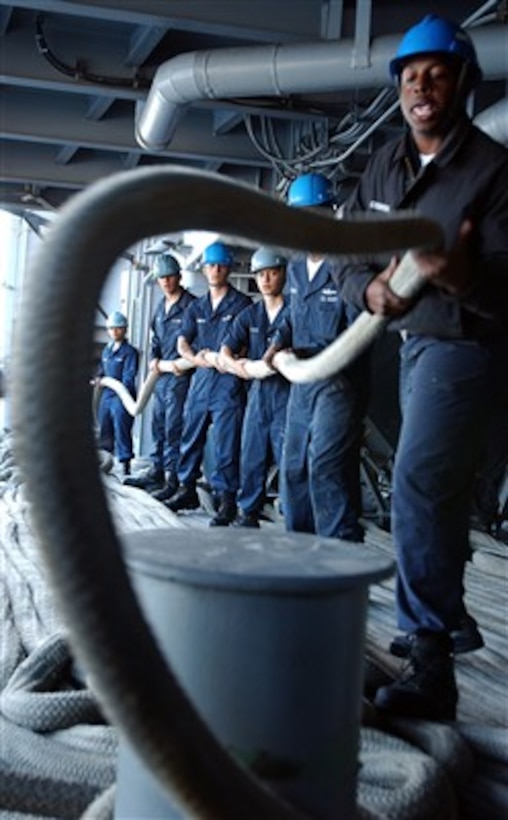 U.S. Navy Seaman Phillip Culbreath whips a mooring line free from around bitts as the USS Ronald Reagan (CVN 76) gets underway from Naval Air Station North Island in San Diego, Calif., on Jan. 27, 2007.  More than 5,500 sailors from the Ronald Reagan Strike Group are departing on a surge deployment in support of U.S. military operations in the Western Pacific.  