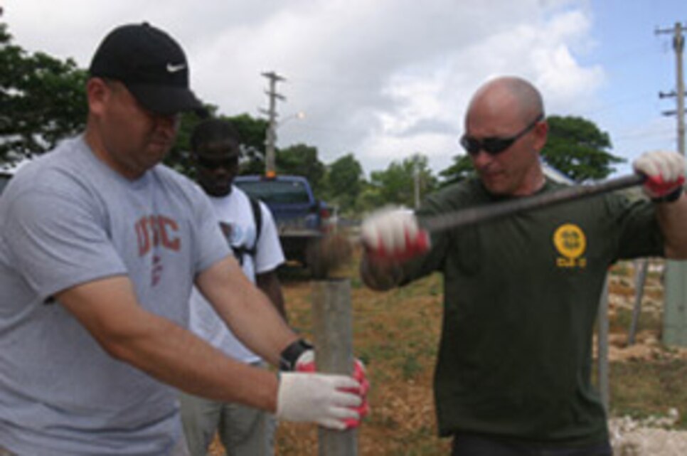Staff Sgt. Oscar Luna (left) and Warrant Officer Colin Cooper pound in a fence rail at the Community Relations project site April 30. Luna, Cooper and a handful of Marines and Sailors from the 13th Marine Expeditionary Unit and Bonhomme Richard Strike Group came together and volunteered free time for the project during a routine port call in Guam. The second of two such projects, service member were tasked with building a fence, planting trees and other beautifications to the village Mayoral Office.