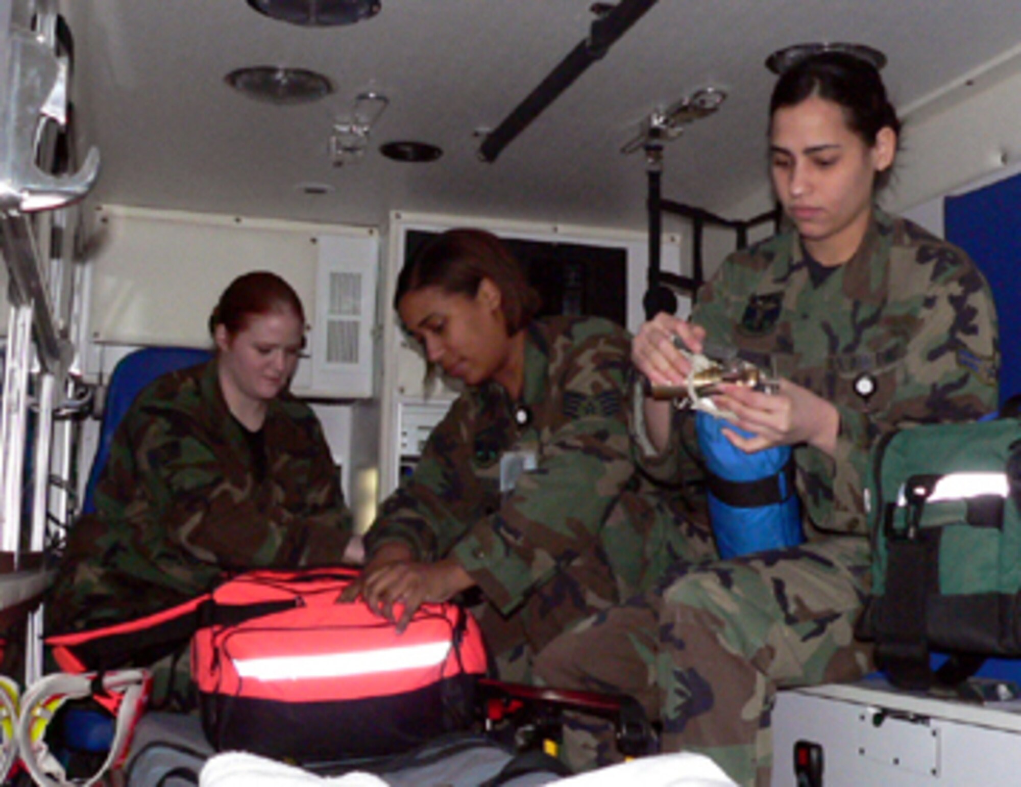 01/29/2007 -- MISAWA AIR BASE, Japan -- Staff Sgt. Melissa Smith (back), Staff Sgt. Trisha Mickles (center), and Airman 1st Class Yara Lebron, 35th Medical Group emergency medical technicians, check their gear in the ambulance. The Medic 1 team responded to a 911 call Jan. 16 at the Misawa Potter Fitness Center.  With the assistance of the base fire department, the first responders were able to resuscitate the victim and medical evacuate him for further treatment. (U.S. Air Force photo by Staff Sgt. A.C. Eggman)