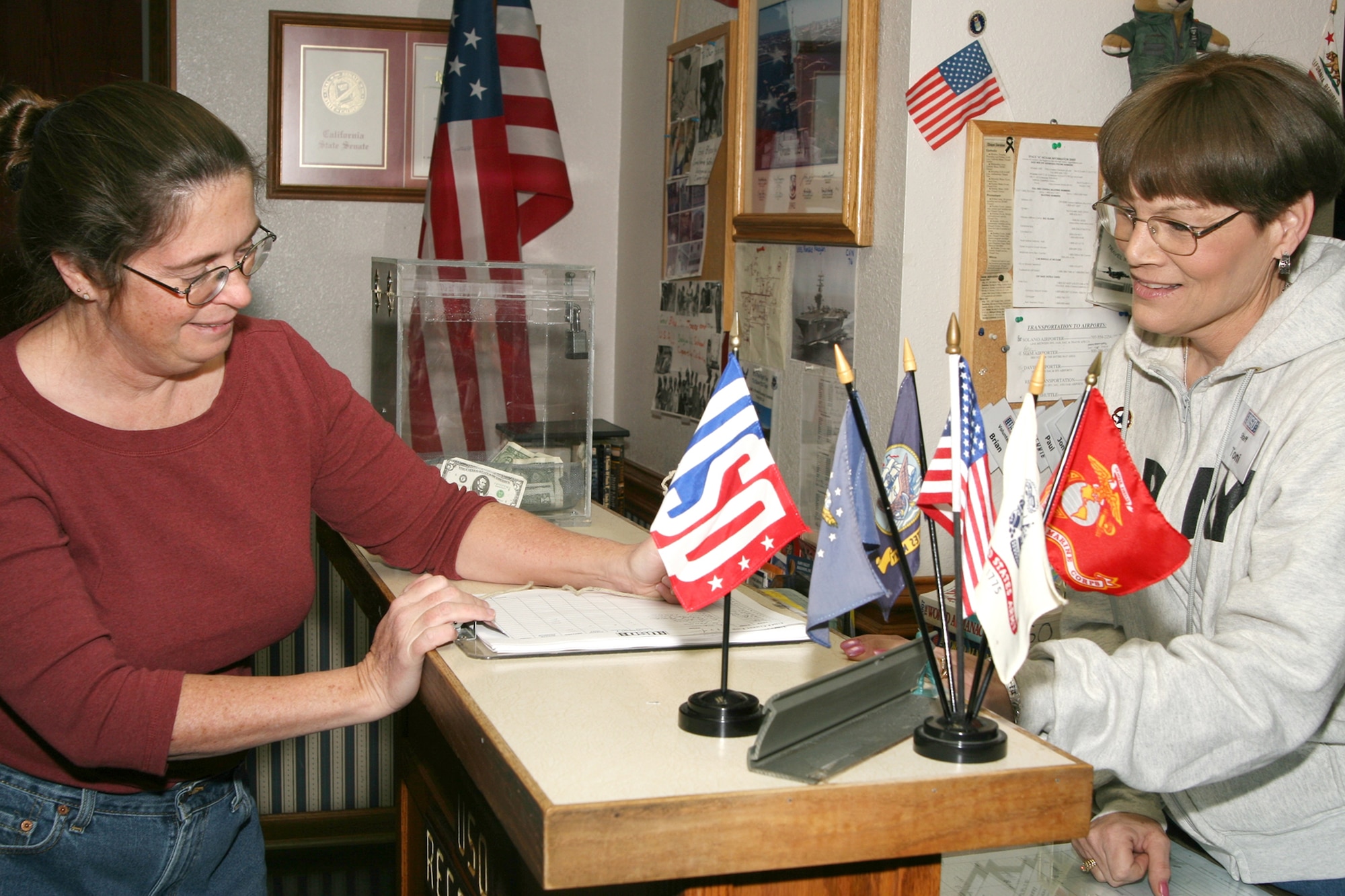 Ms. Toni Cilop, (right), USO staff member, assists Mrs. Jacqueline Wilson sign in at the center. Mrs. Wilson is stationed with her husband in Okinawa, Japan and she and her family visited Travis’ USO during their stay. More than 12,000 people use the center annually, with the majority being families with one parent deployed. (U.S. Air Force photo by Master Sgt. Wendy Weidenhamer.)