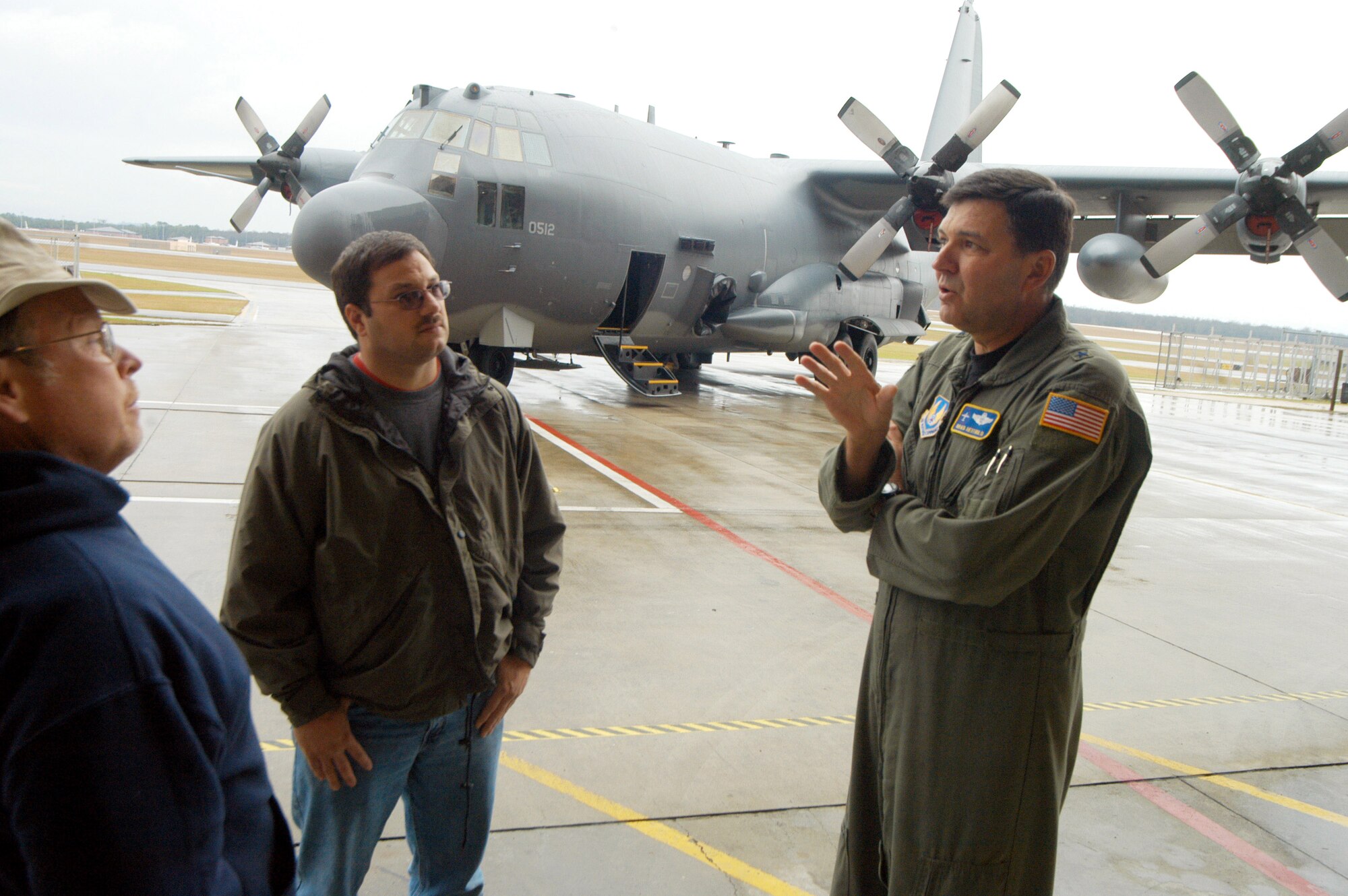 Brig. Gen. Bradley A. Heithold (right) speaks with Dan Richardson and Kevin Kelly in front of the AC-130U Gunship after a release ceremony Jan. 22 at Robins Air Force Base, Ga. Maintainers repaired the gunship in only 146 days and four days ahead of schedule. (U. S. Air Force photo/Sue Sapp)