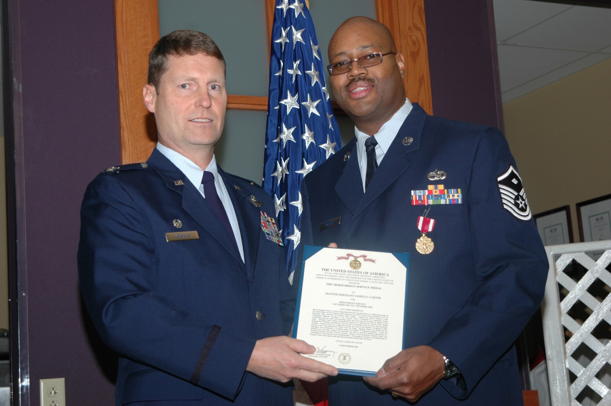 GRISSOM AIR RESERVE BASE, Ind., -- Master Sgt. James Carter, 434th Logistics Readiness Squadron, receives an Air Force Meritorious Service Medal from Col. Doug McHugh, 434th Support Group commander, during a commander's call held on the January unit training assembly. (U.S. Air Force Photo/Senior Airman Chris Bolen)