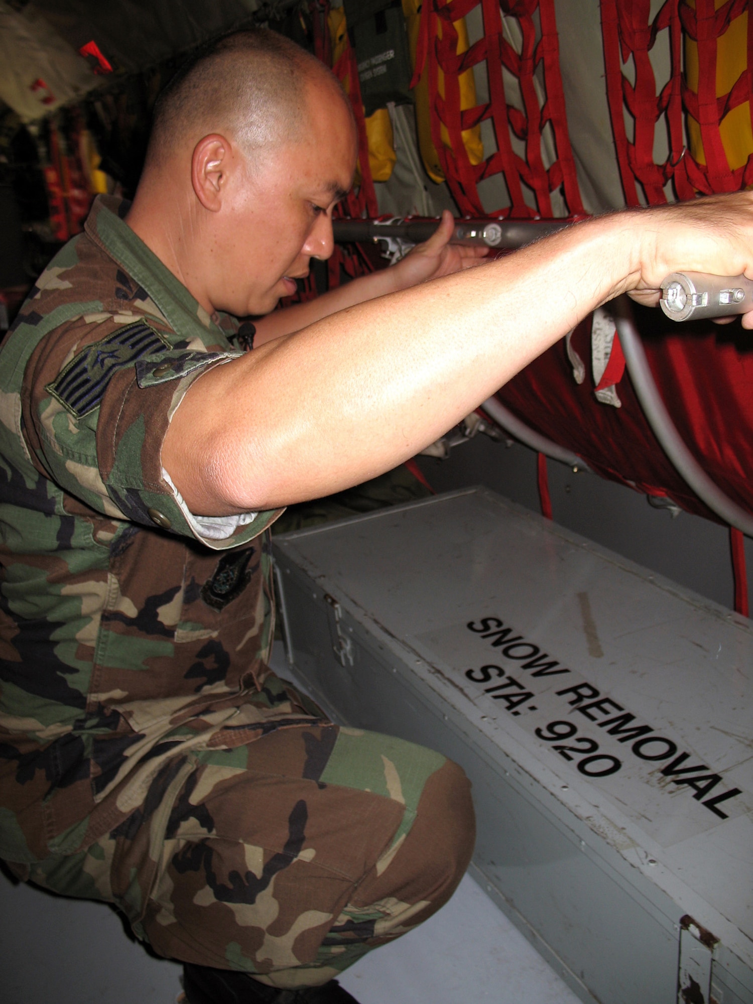 Tech. Sgt. Steward Leong shows an example of excess equipment that could be taken off of a KC-135 Stratotanker at Hickam Air Force Base, Hawaii, on Jan. 25. Removing excess equipment is part of a KC-135 fuel-saving initiative. Sergeant Leong is a KC-135 crew chief with the Hawaii Air National Guard's 154th Aircraft Maintenance Squadron. (U.S. Navy photo/Petty Officer Jason Segedy)