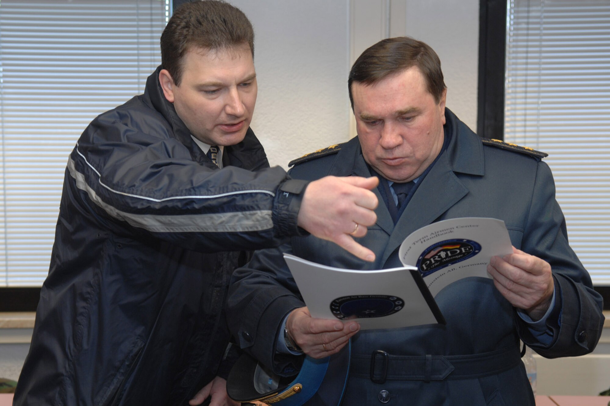 Gen.-Col. Anatoliy Yakovich Toropchyn (right)  reviews a copy of the First Term Airman Center's handbook alongside interpreter Valeriy Ilyashenko during his visit to the FTAC at Ramstein Air Base, Germany. During his four-day visit, General Toropchyn met with senior U.S. Air Forces in Europe leaders to become familiar with organizational missions, air operations and planning, as well as enlisted and officer training and development. (U.S. Air Force photo/Staff Sgt. Rasheen A. Douglas)
