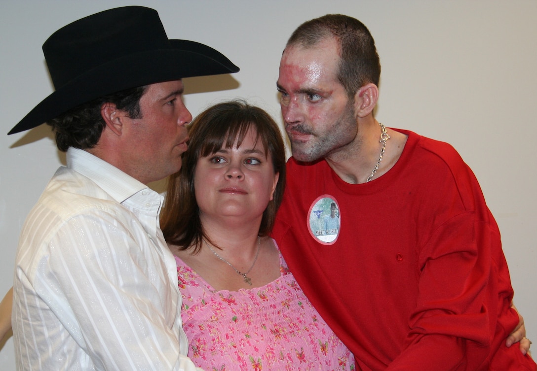Army Staff Sgt. Christopher Edwards and his wife, Tammy, talk with country music singer Clay Walker during a Feb. 14 visit to Brooke Army Medical Center. Edwards, a burn patient at BAMC, is usually in a wheelchair but insisted on standing when greeting Walker. Photo by Nelia Schrum