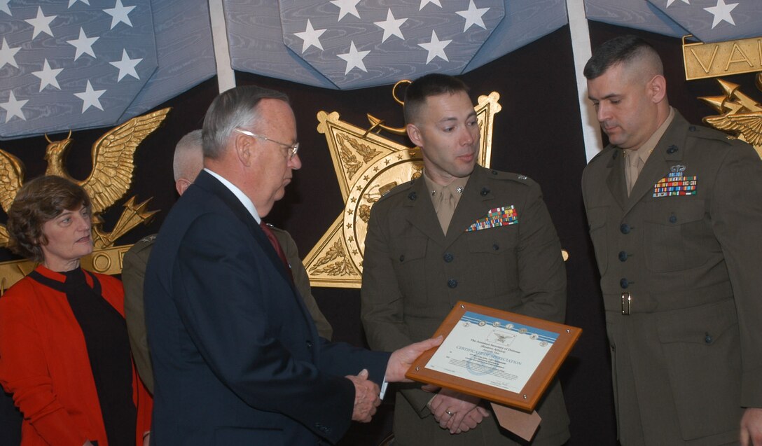 Thomas F. Hall, assistant secretary of defense for reserve affairs, left, presents the 2005 DoD Reserve Affairs Family Support plaque to Lt. Col. John G. Scott, commander, Peacetime Wartime Support Team, Battery A, 1st Battalion, 14th Marines, and Maj. Richard P. Faucher Jr., officer in charge of the Peacetime Wartime Support Team, Headquarters Battery, 1st Battalion, 14th Marines. Photo by Rudi Williams