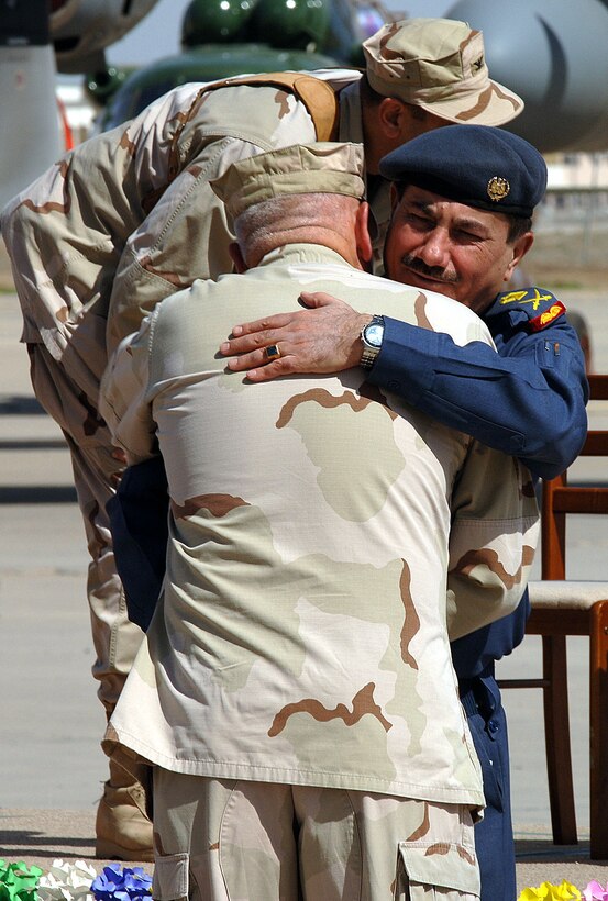 Maj. Gen. Kamal Barzanjy, Iraq air force chief of staff, hugs U.S. Air Force Lt. Col. Michael Mawson, Multinational Security Transition Command Iraq's Coalition Air Force Transition Team senior base support unit adviser, at the formal stand-up ceremony for the new Al Muthana Air Base in Iraq March 7. Photo by Master Sgt. Will Ackerman, USAF
