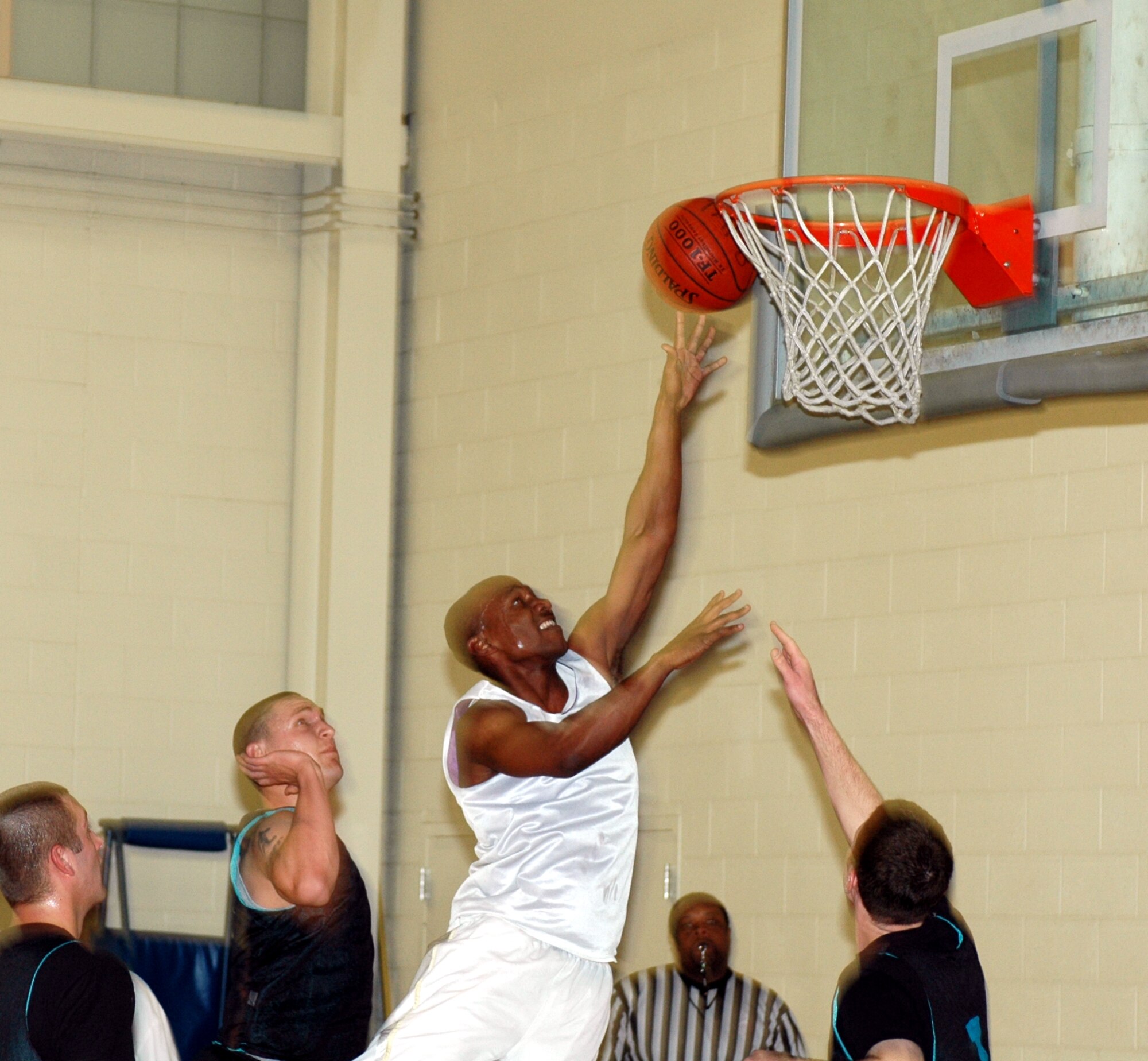 Sherron DeBerry, 60th Aerial Port Squadron point guard, attempts a tough layup during the 60th APS 28-21 loss to the 60th Aircraft Maintenance Squadron Jan. 30. DeBerry scored his team’s first points after the 60th AMXS opened the game with a 10-0 win. (U.S. Air Force photo by Staff Sgt. Candy Knight)