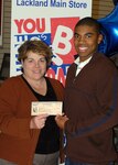 Xavier Ferguson receives a $5,000 U.S. Savings Bond from Julie Cosby, San Antonio general manager of the Army and Air Exchange Service, as a winner in the AAFES "You Made the Grade" program. He is the son of Tech. Sgt. Craig Ferguson, Cryptologic Systems Group. The program recognizes Lackland Air Force Base students for academic achievement. Students receive coupon booklets which include free admission to a movie and other treats. Each booklet contains a form for a quarterly drawing for a $2,000, $3,000 or $5,000 savings bond. (USAF photo by Alan Boedeker)