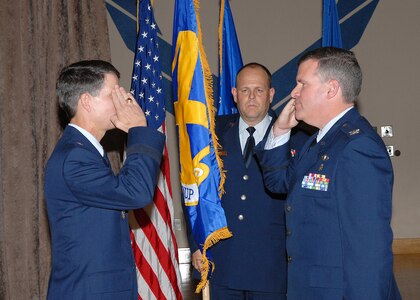 Brig. Gen. Darrell Jones, commander of the 37th Training Wing, left, returns the salute of Col. Tim Halligan as the colonel assumes command of the newly reactivated 37th Medical Group during a formal ceremony Jan. 25 at the Gateway Club on Lackland Air Force Base, Texas. Chief Master Sgt. Bob Rubio stands behind them with the group flag. (USAF photo by Robbin Cresswell