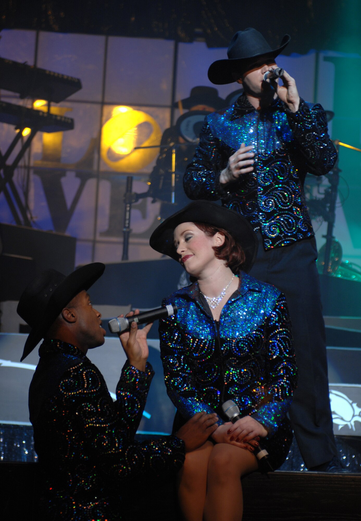 Dyess Air Force Base, TX - 1 LT Rachel Rogers of Shaw AFB, South Carolina is serenaded by two of her cast mates at the tops in Blue performance Tuesday night. The cast members must be able to do wardrobe changes and hair and makeup touchups all within the change of a song. (U.S. Air Force photo by Airman Jennifer Romig)