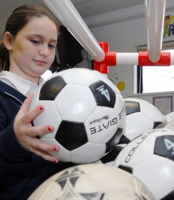 Christy Hawking, 10, contributes to Tolleson Elementary School's donation of soccer balls for Djibouti children Jan. 31. Christy has already made a donation of 14 soccer balls to the schools collection box. The school hopes to collect at least one soccer ball per student to "Operation Play," donating more than 300 altogether. (Photo by Staff Sgt. Jonathan Pomeroy)