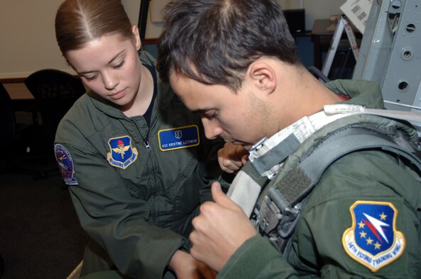 Airman 1st Class Kristine Lessman, 14th Medical Operations Squadron, goes over in-flight emergency procedures with Joe King, The Fray guitarist, prior to his flight Tuesday. The band had lunch with CAFB members and received orientation flights in T-37s before their concert in Starkville. (Photo by Senior Airman John Parie)