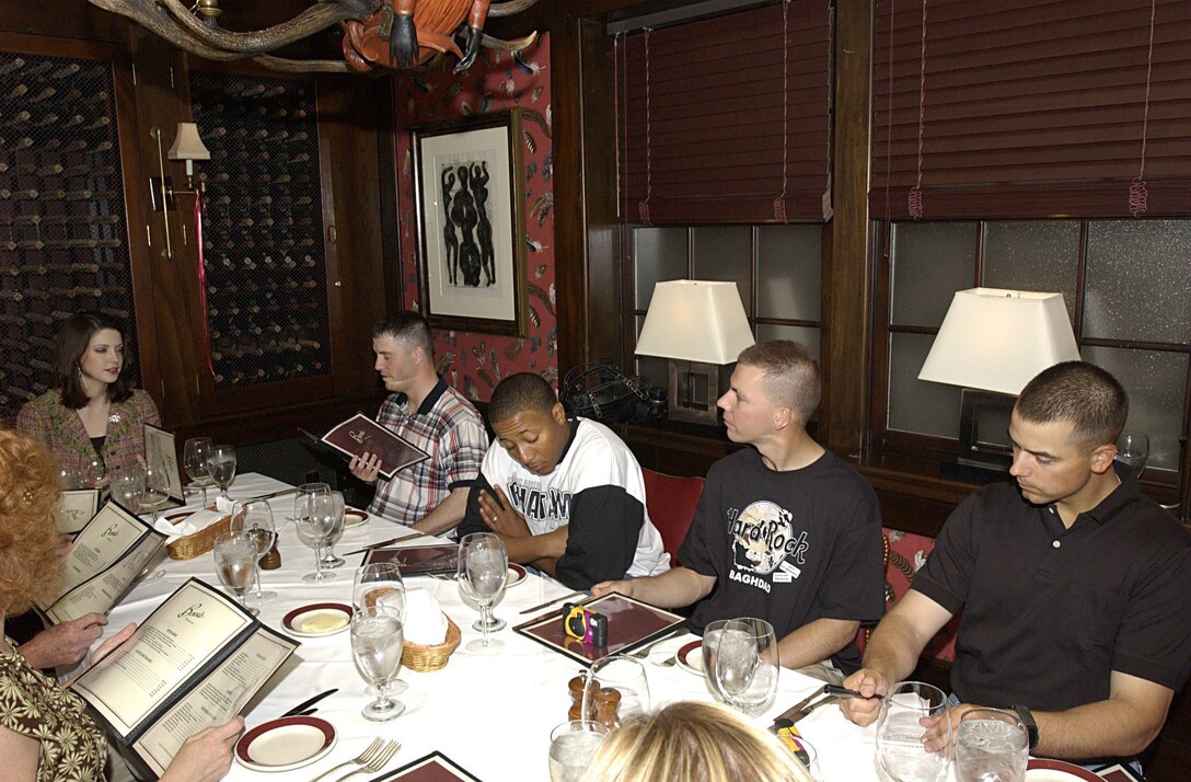 Deidre Downs, better known as Miss America 2005, sits down to eat with Georgia-based soldiers Sgt. Robert Griffin, Spc. Brent Goolsby, 2nd Lt. Stephen Lucas, and Staff Sgt. Terence Alford, who were just arriving back from Iraq for some rest and recuperation, during a July 3 dinner in Atlanta. Photo by Spc. Jonathan Montgomery, USA