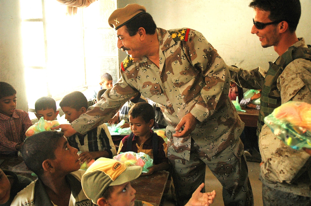 Iraqi Brig. Gen. Mahdi, commander of 4th Brigade, 6th Iraqi Army Division, reaches out to students at a school Sept. 14. "These children are the future of Iraq," Mahdi said. "The children of Iraq are going to lead the future." Photo by Spc. Tracy J. Smith, USA