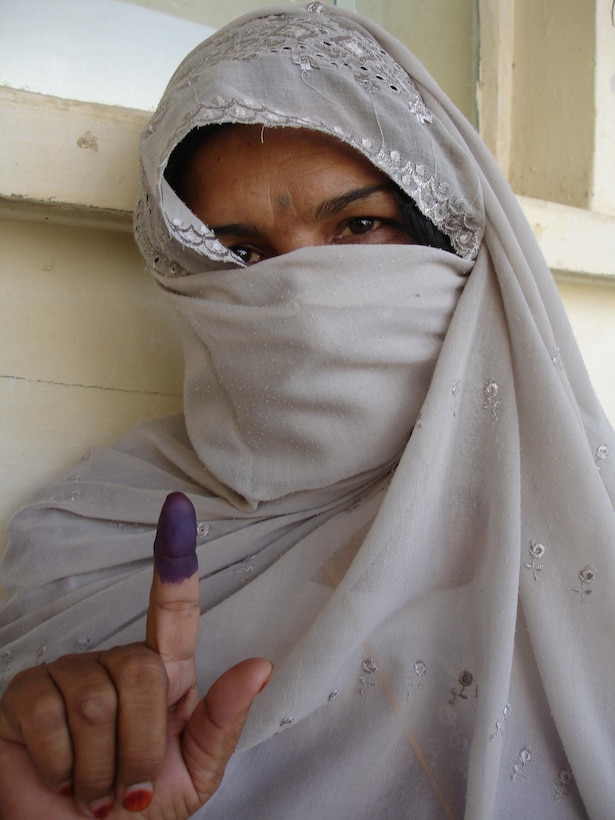 Signifying her vote, an Afghan woman proudly displays her ink-stained finger Sept. 18 in Lash Kar Gah in Afghanistan's Helmand province. Photo by 1st Sgt. Stephanie Hika, USA

