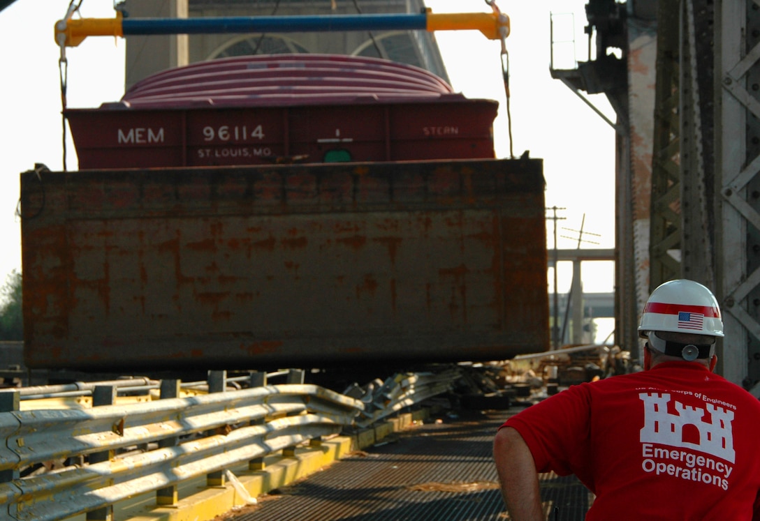 Stuart Waits of the New Orleans District, Army Corps of Engineers, oversees the removal of a barge from the Almonaster Ave. Bridge, also known as the L&N railroad bridge on Sept. 14. Hurricane Katrina's storm surge deposited this barge and another on the bridge, rendering it inoperable and cutting off access to the northern portion of the Industrial Harbor Navigation Canal from the south.  The other barge was removed a day earlier.  USACE Photo