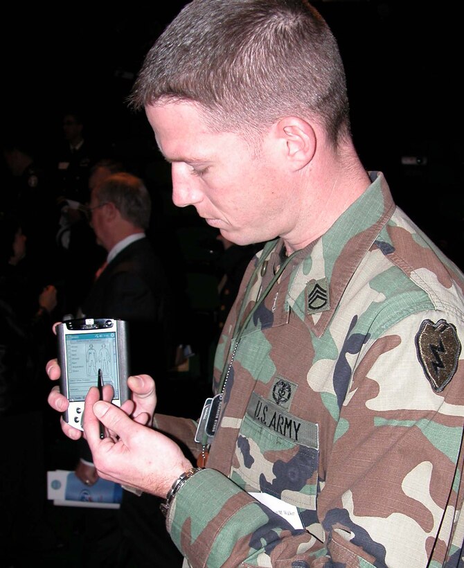 Army Staff Sgt. Kevin M. Walker, a combat medic assigned to the 1st Stryker Brigade, 25th Infantry Division, Fort Lewis, Wash., demonstrates a portable medical data collector that's used by American forces in Iraq. Walker participated in the Nov. 21 rollout ceremony for the military's electronic medical records system held at the National Naval Medical Center in Bethesda, Md. Photo by Gerry J. Gilmore