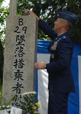 Lt. Col. Anthony Thomas, 374th Communications Squadron commander, pours bourbon on to a B-29 memorial statue for the Shizuoka City memorial service. The ceremony is held every year in memory of those who died during a B-29 air raid over the city on June 19,1945.
(U.S. Air Force photo by Senior Airman Veronica Pierce).  