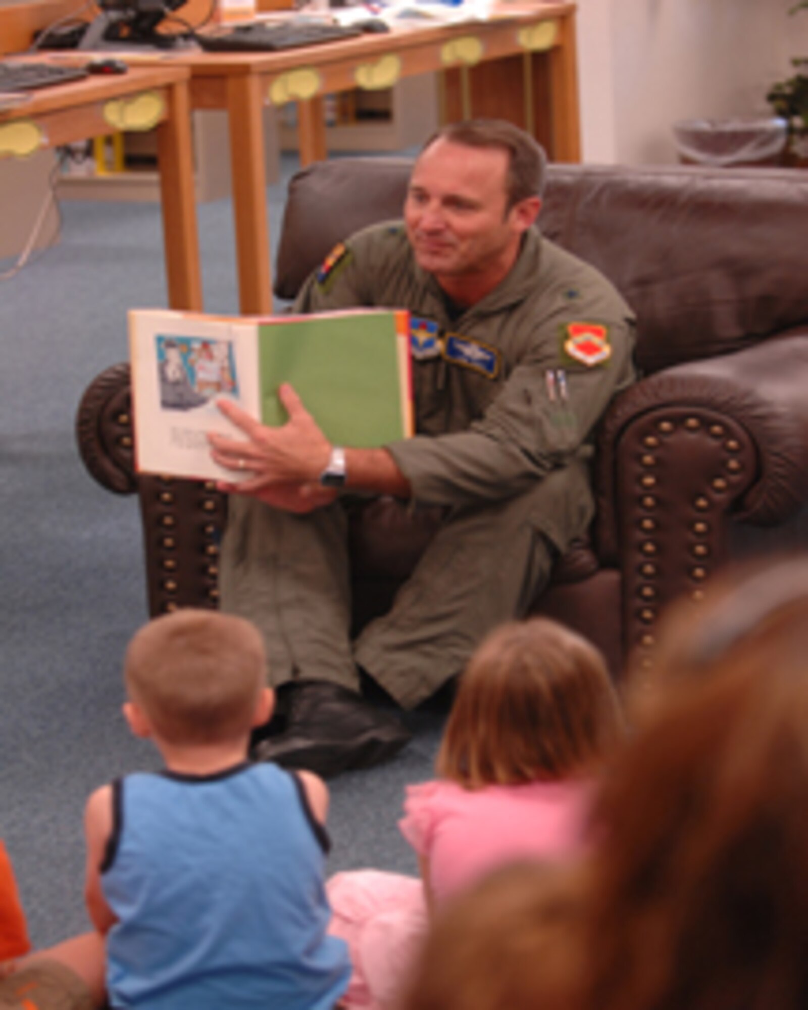 Brig. Gen. Tom Jones, 56th Fighter Wing commander, kicks off the summer reading
program June 21 at the library by reading “Jake Gander Storyville Detective” to Luke youth. The program theme is Get a Clue @ Your Library and meets at 9:30 a.m. Thursdays in July. Topics include history’s mysteries, stories and crafts Thursday; Crack the Code, stories and crafts July 12; magical mysteries with The Wiz July 19; and the grand finale and prize ceremony July 26. Participants must be present to win. (Photo by Tech. Sgt. Jeffrey Wolfe)