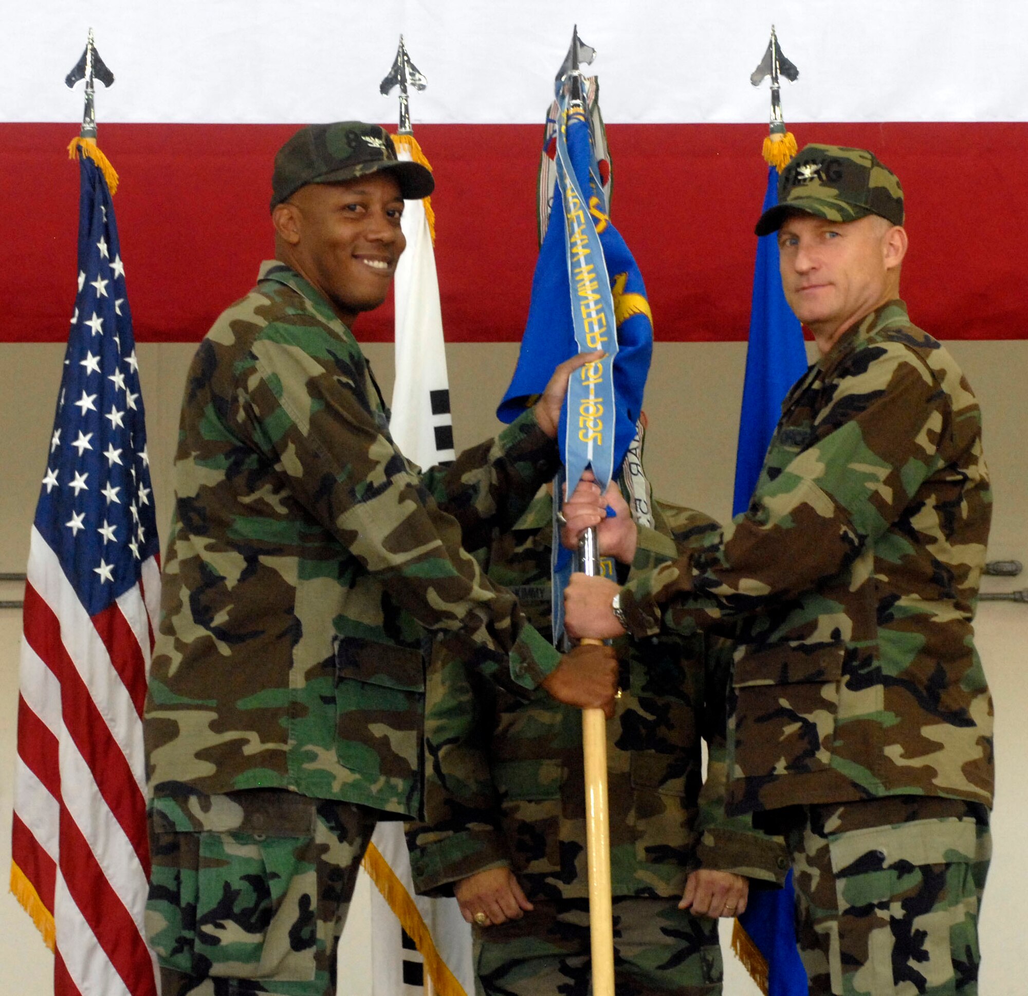 KUNSAN AIR BASE, Republic of Korea -- Col. Michael "Phoenix" Kucej, 8th Maintenance Group commander (right) receives the group's guideon from Col. CQ "Wolf" Brown, 8th Fighter Wing commander, during an assumption of command ceremony July 2 here. (U.S. Air Force photo/Senior Airman Steven R. Doty)
