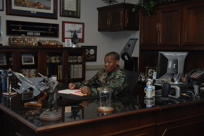 Staff Sgt. Sheldon Grant, 99th Services Squadron, reviews paperwork for an up coming event during his day of shadowing the commander of the 99th Air Base Wing, Col. Michael Bartley, June 12