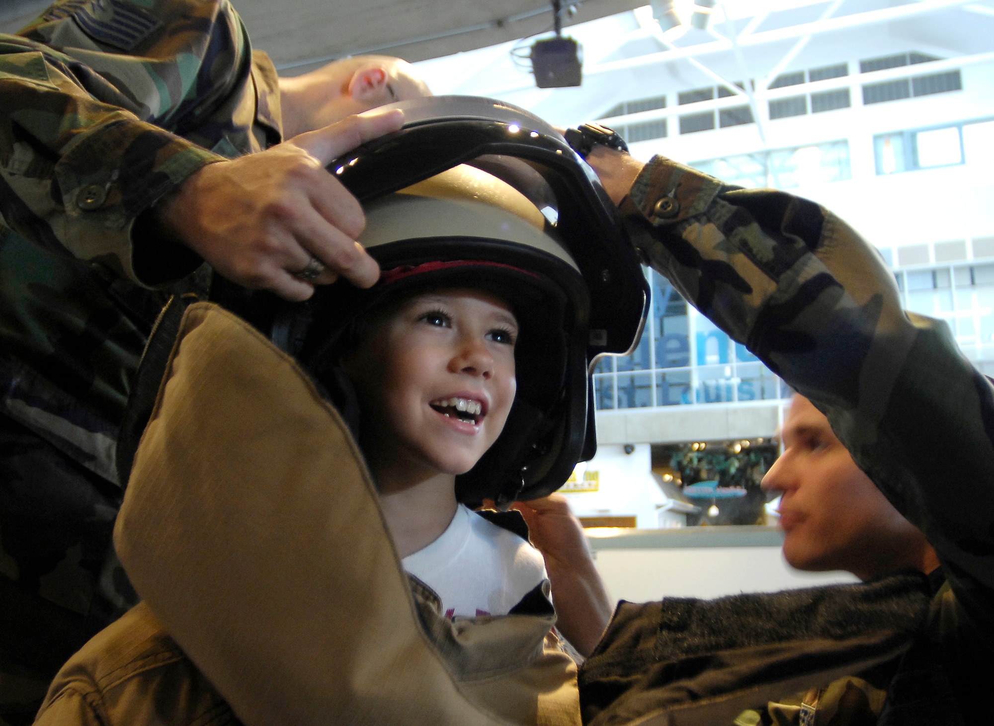 Tech. Sgt. Neil Jones (left) and Senior Airman David Gerig adjust the helmet of an explosive ordnance disposal bomb suit for 7-year-old Joe Trout during his visit July 2 to the Saint Louis Science Center. EOD technicians were on hand at the center for the kickoff of Air Force Week being celebrated in St. Louis, this week. The Airmen are assigned to the 375th Civil Engineer Squadron at Scott Air Force Base, Ill. (U.S. Air Force photo/Staff Sgt. Brian Ferguson) 