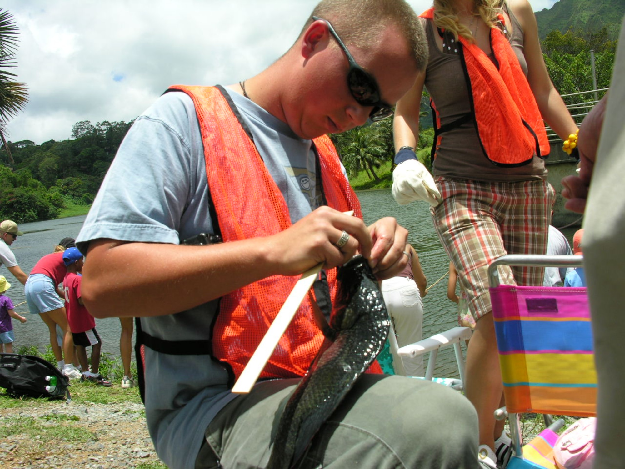 Airman 1st Class Matt Nelson, 561 Communications Squadron, Det. 1, a volunteer fishing martial, measures the 13-inch fish, caught by Peyton Killen. Photo by Senior Airman Erin Smith