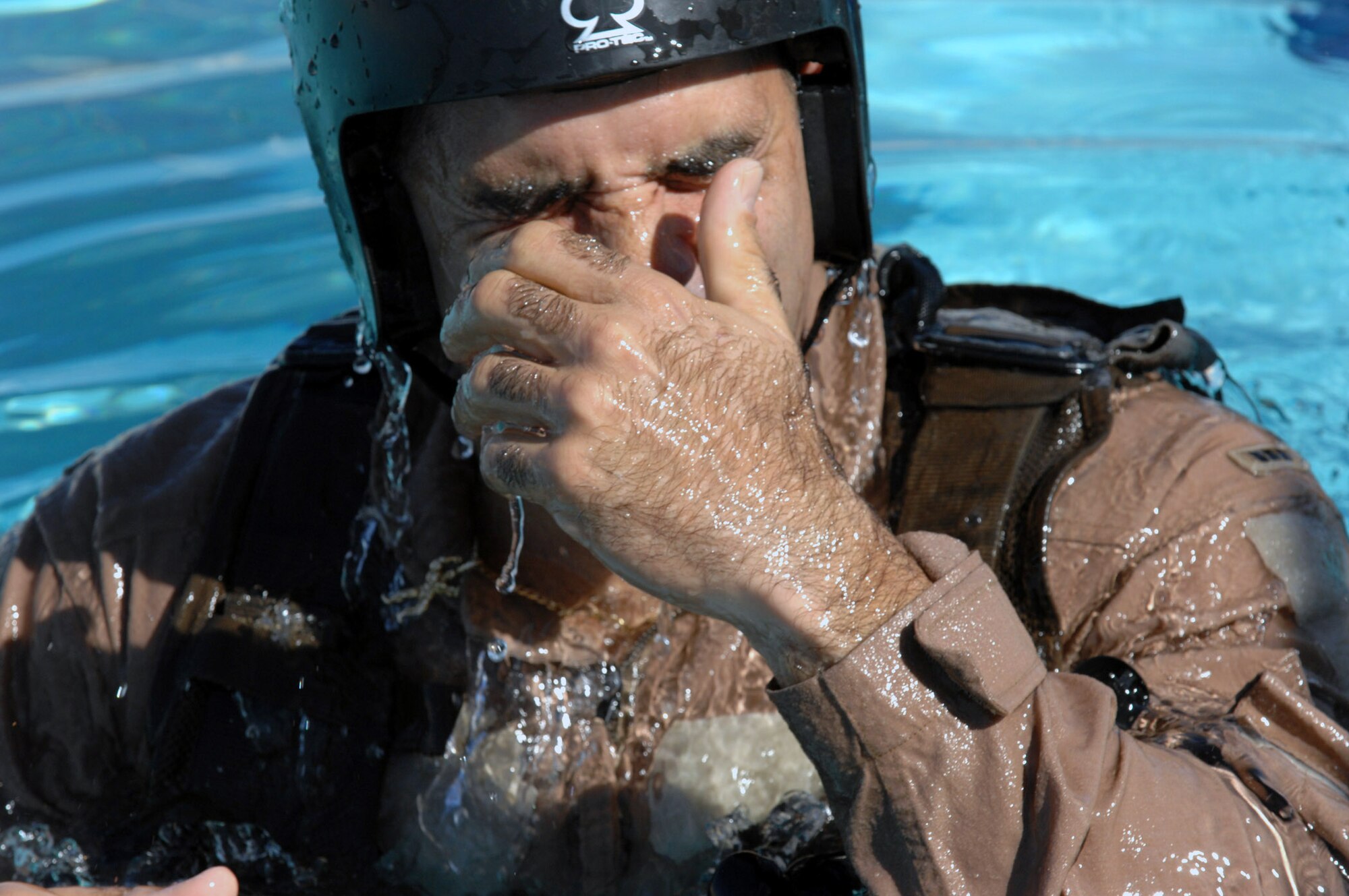 Army Chief Warrant Officer Ralph Hernandez wipes his eyes after exiting a helicopter underwater dunker device during his annual water survival training.  The training is conducted by survival, evasion, resistance and escape, or SERE, instructors at Nellis Air Force Base, Nev.  The Army National Guardsman is an OH-58 Scout instructor pilot.  (U.S. Air Force photo/Master Sgt. Kevin J. Gruenwald)