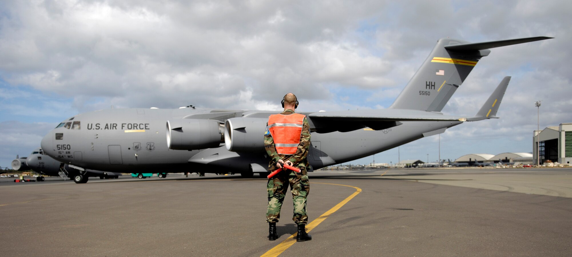 Tech. Sgt. Brad Sufka, 15th Aircraft Maintenance Squadron crew chief, marshals a C-17 Globemaster III. They are practicing for the Air Mobility Command Rodeo at McChord AFB, Wash. in July. Photo by Senior Airman Erin Smith
