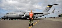 Tech. Sgt. Brad Sufka, 15th Aircraft Maintenance Squadron crew chief, marshals a C-17 Globemaster III. They are practicing for the Air Mobility Command Rodeo at McChord AFB, Wash. in July. Photo by Senior Airman Erin Smith
