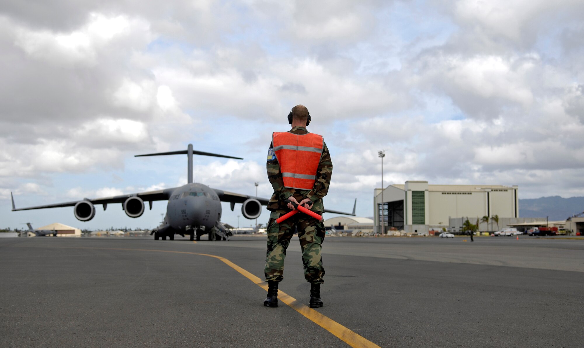 Tech. Sgt. Brad Sufka, 15th Aircraft Maintenance Squadron crew chief, marshals a C-17 Globemaster III. They are practicing for the Air Mobility Command Rodeo at McChord AFB, Wash. in July. Photo by Senior Airman Erin Smith
