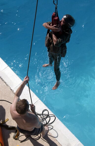 Staff Sgt. Michael Nettleingham hoists Army Chief Warrant Officer Ron Stone out of the water during a simulated helicopter rescue.  Sergeant Nettleingham is a survival, evasion, resistance and escape, or SERE, instructor at Nellis Air Force Base, Nev.  The Army National Guardsmen, an OH-58 Scout maintenance officer, was taking his annual water survival training.  (U.S. Air Force Photo/Senior Airman Larry E. Reid Jr.)