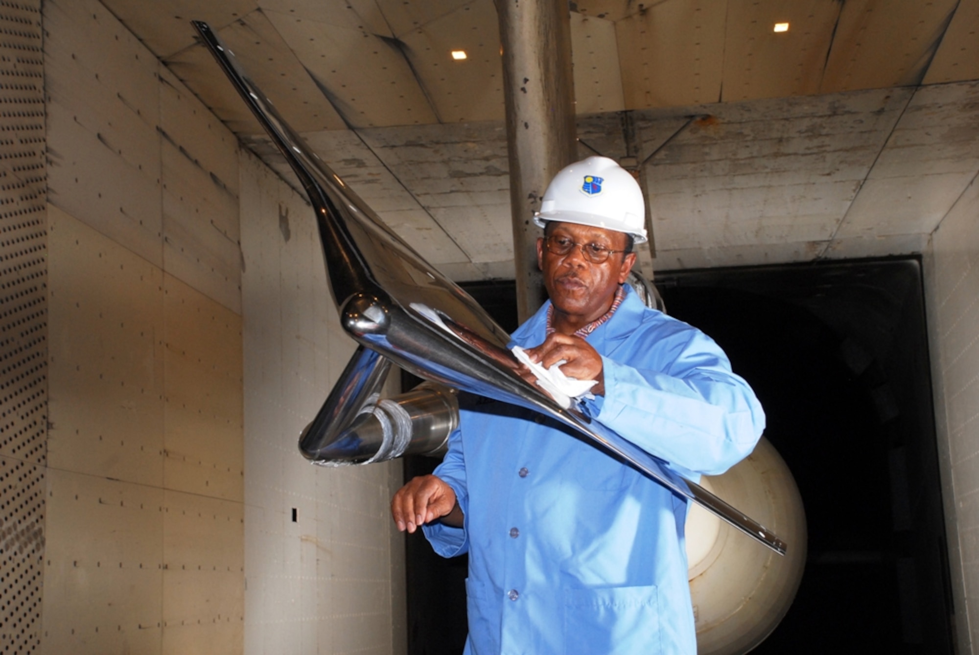 Aerospace Testing Alliance Outside Machinist  Joe Sanders cleans and inspects the upper surface of the Blended Wing Body concept test article during a model change prior to the resumption of aerodynamic testing in AEDC’s 16-foot transonic wind tunnel. (Photo by David Housch)