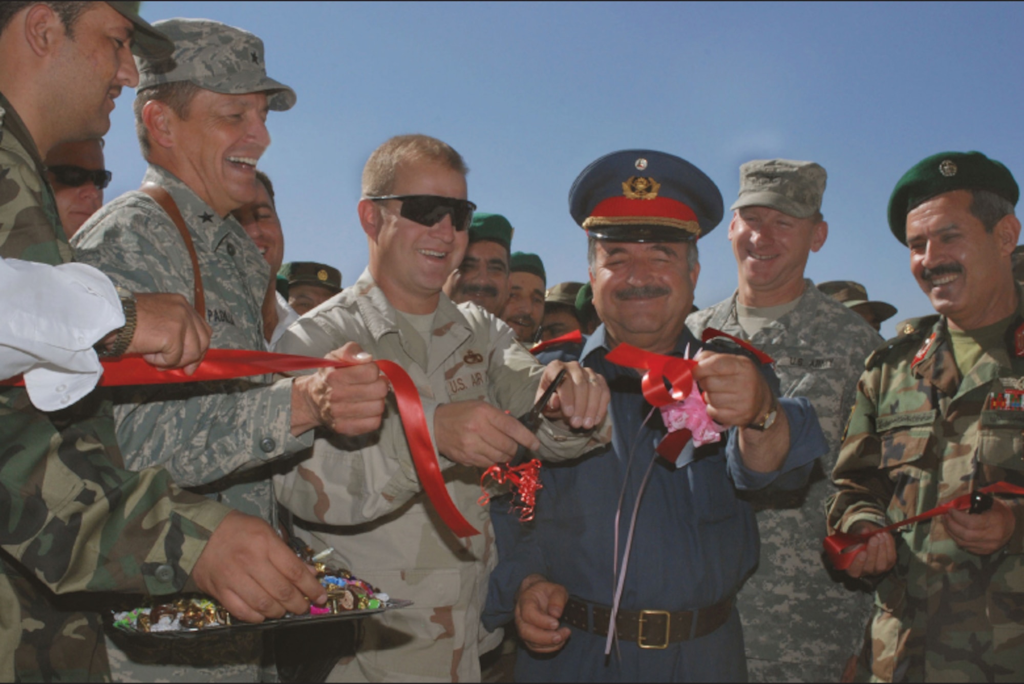 EIELSON AIR FORCE BASE, Alaska--Master Sgt. Mike Stoller, 354th Logistics Readiness Squadron, cuts the ribbon on a new $4 million vehicle repair facility with Afghanistan National Army Maj. Gen. Douran, ANA Brig. Gen. Wahab, and Air Force Brig. Gen. Frank Padilla. Sergeant Stoller is currently deployed to Kabul Air Base, Afghanistan under the Combined Security Transition Command. (U.S. Air Force photo by Petty Officer First Class David Votroubek)