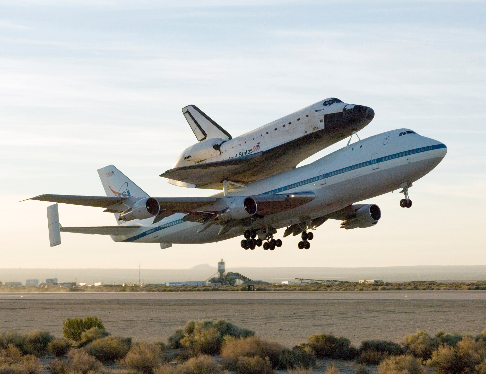 The Space Shuttle Atlantis, mounted on top of NASA's 747 Shuttle Aircraft Carrier, takes off from Edwards Air Force Base, Calif. early Sunday morning. The shuttle ferry flight ends Atlantis' nine-day visit to Edwards after landing on June 22. (NASA photo by Carla Thomas)
