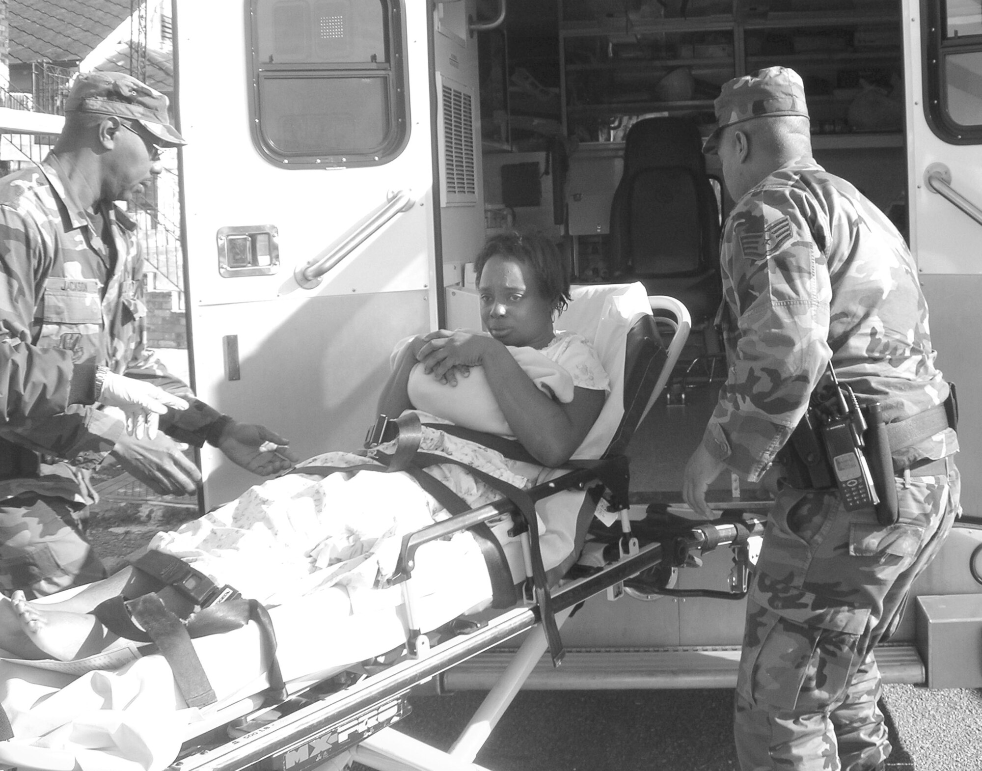 Staff Sgts. Tommy Jackson, left, and William Campbell load a newborn baby boy and his mother into an ambulance bound for the hospital, after Sergeant Campbell helped emergency medical technicians with the baby's delivery.
(U.S. Air Force photo/Technical Sgt. Suzanne Chaillot)
